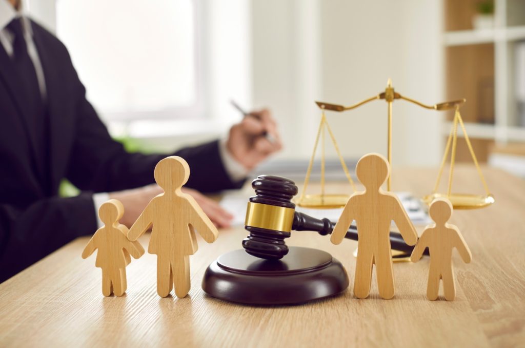 Gavel and small miniature wooden personas on the office table of a legal professional where he's sitting and working