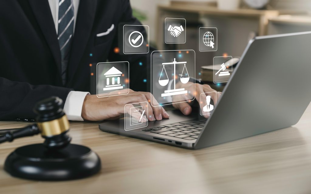 Person working on laptop with signs of the legal system appearing virtually on the image